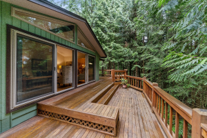 A deck built outside of a house near trees