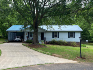 A photo showing a home with a light blue roof