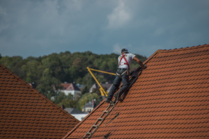 Roofer working on a roof, installing new roofing materials.