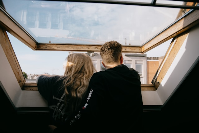 Two individuals looking from a skylight