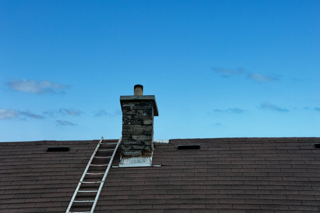 Ladder placed on the roof of a house for chimney inspection and repair by professional contractors in NY.