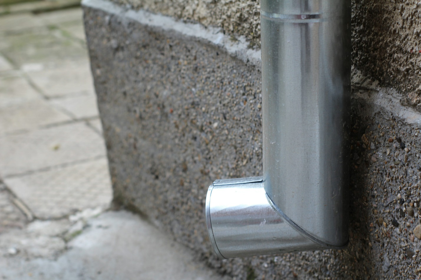 Metal gutter installed on a wall, showing the importance of regular gutter maintenance and professional cleaning to protect the structure of your home.