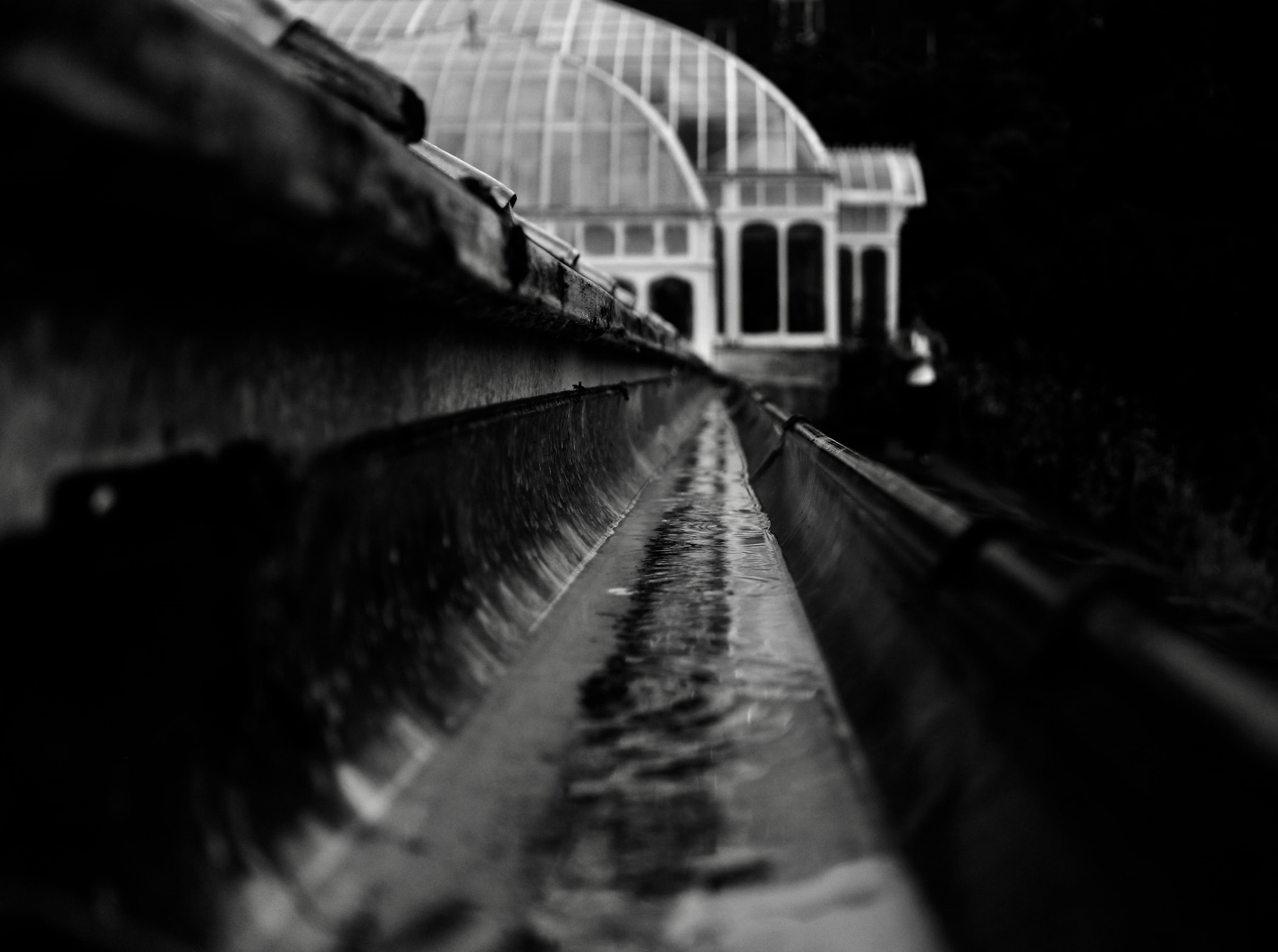 Close-up of water flowing through a gutter system, demonstrating effective drainage and foundation protection.