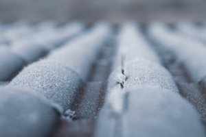 Frost-covered roof in New York highlighting potential winter roof damage and the need for timely roof repair.