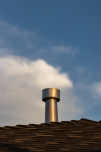 A sturdy metal chimney on a rooftop with proper flashing to prevent leaks.
