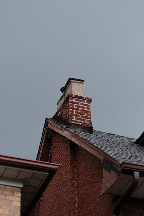 New York home with a prominent rooftop chimney surrounded by a clean, well-maintained roof.